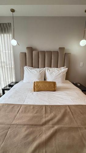 a large white bed with a large brown blanket on it at Luxury apartment 10 min to Airport Be Cariari Condo #402 in La Asunción