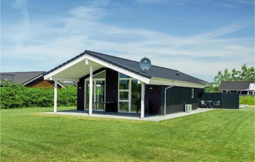 a house with a black roof and a yard at Three-Bedroom Holiday Home In Tarm in Tarm