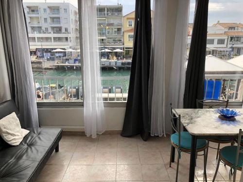 une pièce avec une grande fenêtre avec une table et des chaises dans l'établissement Appartement T 2 meublé sur canal, à Palavas-les-Flots