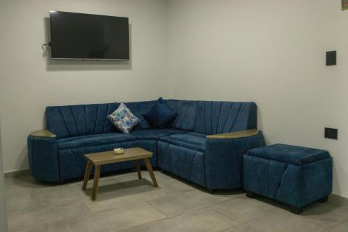 a living room with a blue couch and a table at Hotel Mall plaza in Santa Marta