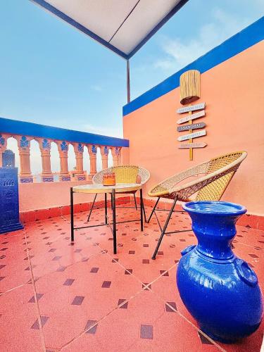 a patio with a table and chairs and a vase at Apartment with AC, patio and ROOFTOP Appartement CLIMATISÉ avec patio et toit terrasse in Marrakech