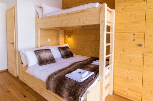 a bedroom with two bunk beds in a log cabin at Chalet Les Rahâs by Mrs Miggins in Grimentz