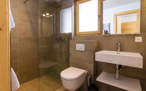 a bathroom with a toilet and a sink and a shower at Chalet Les Rahâs by Mrs Miggins in Grimentz