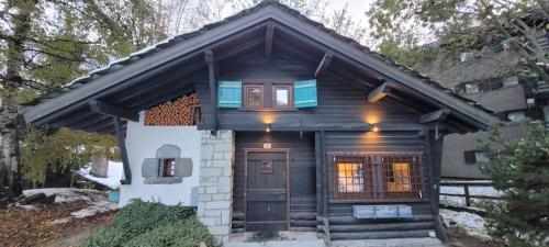 a small log cabin with a door and a window at Chalet in Courmayeur near Lifts & Centre 2BR 2BA in Courmayeur