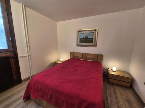 - une chambre avec un lit rouge et 2 tables de chevet dans l'établissement Résidence Grandes Platieres 2 - Appartement lumineux · Proche pistes et commerces MAE-1761, à Tignes