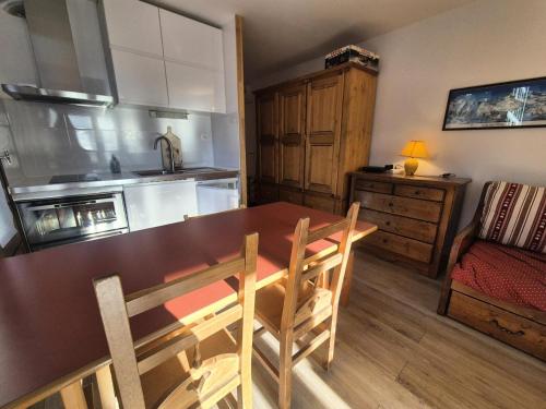 une cuisine avec une table en bois et une salle à manger dans l'établissement Résidence Grandes Platieres 2 - Appartement lumineux · Proche pistes et commerces MAE-1761, à Tignes