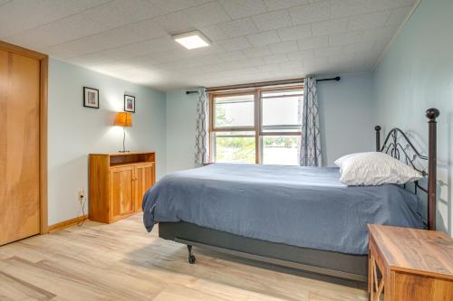 a bedroom with a bed and a window at Lakefront Home with Fire Pit in Eagle River in Eagle River