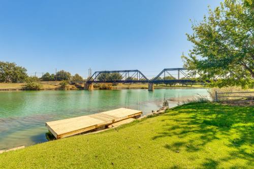 a bridge over a river with a wooden dock at Lakefront Unit with Dock in Carlsbad! in Carlsbad