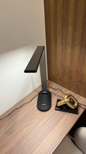 a black object sitting on top of a wooden desk at Luxury apartment 10 min to Airport Be Cariari Condo #402 in La Asunción