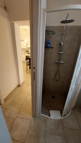 a shower with a glass door in a room at Eusebio's House in Cisternino