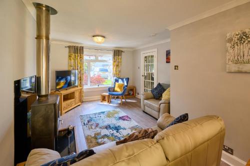 a living room with a couch and a wood stove at Charming 2BD House - Parking & Garden in Oban in Oban