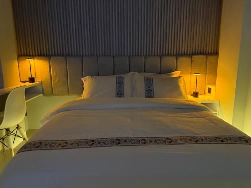 a large white bed with two lamps on either side of it at Mayweed in Male City