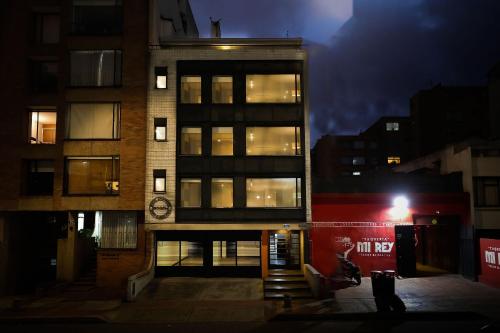 een man die 's nachts voor een gebouw staat bij Bogo64 in Bogota