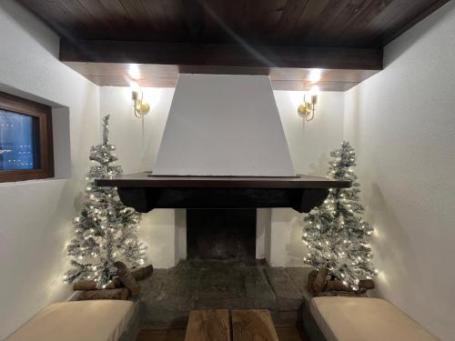 a living room with a fireplace with christmas trees at Chalet in Courmayeur near Lifts & Centre 2BR 2BA in Courmayeur