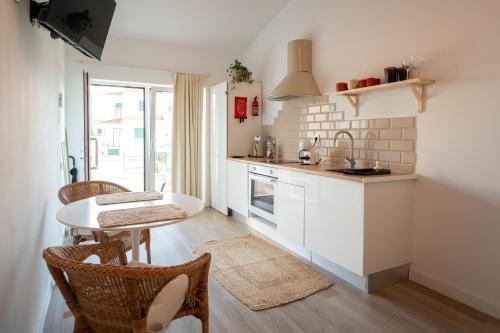 a kitchen with a table and chairs and a sink at Casa do Rio in Nazaré