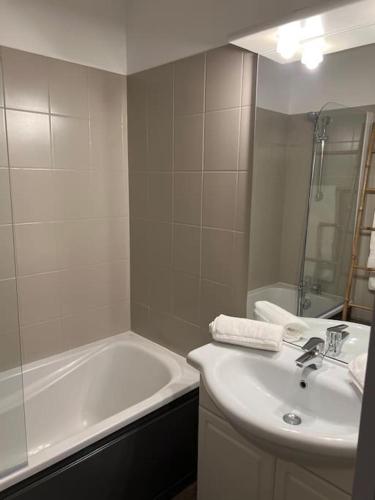 a white bathroom with a sink and a bath tub at Beaune Levernois, appartement 1 chambre canapé lit in Levernois