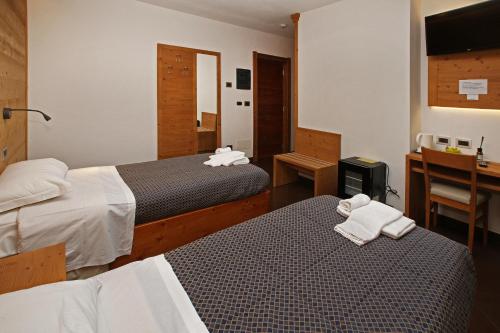 a hotel room with two beds and a desk at Chalet ALLEMAND in Sauze dʼOulx