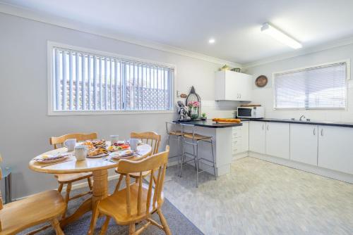 a kitchen and dining room with a table and chairs at Lorikeet Retreat 2 Pet Friendly Air Conditioned Holiday House in Shoal Bay