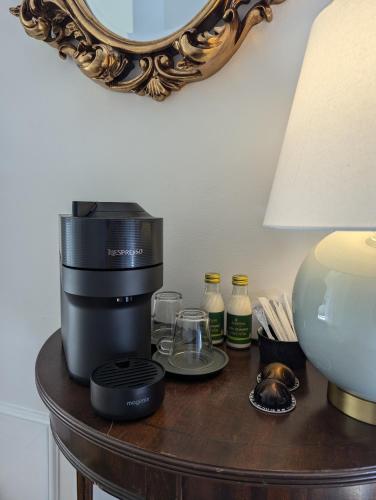 a coffee maker on a table next to a lamp at The Duke Hotel in Hilmarton