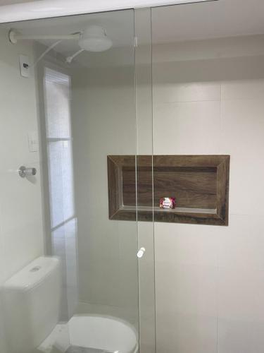 een badkamer met toilet en glazen douche bij Barra Beach Club CASAS in Florianópolis