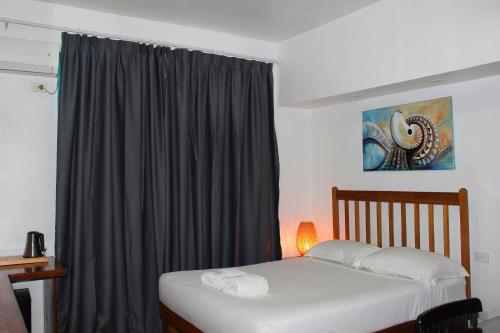 a bedroom with a bed and a window with at Pacific Crown Hotel in Honiara