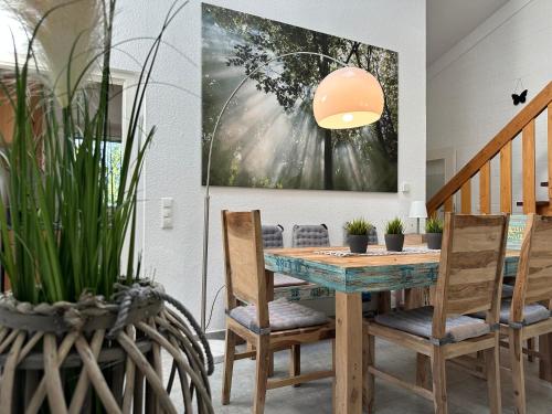 a dining room with a table and chairs and a painting at Komfortables Ferienhaus 80qm unweit vom See in Lichtenberg - Frankenwald - Bad Steben - Hof Saale in Lichtenberg
