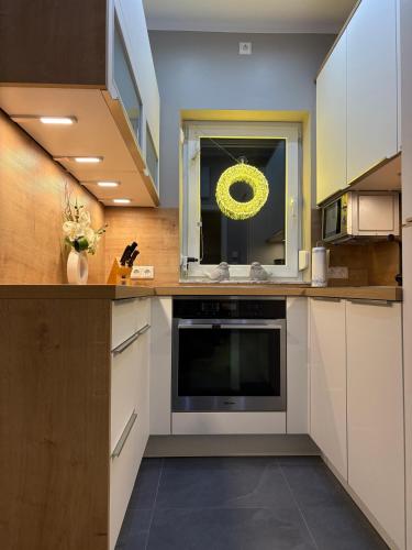 a kitchen with white cabinets and a microwave at Komfortables Ferienhaus 80qm unweit vom See in Lichtenberg - Frankenwald - Bad Steben - Hof Saale in Lichtenberg