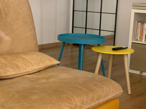 a table and a stool next to a chair and a remote control at Casa del sole in Nova Siri Marina