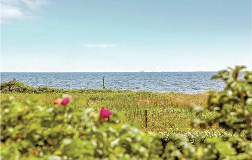 a view of the ocean from a field with flowers at Three-Bedroom Holiday Home In Ebeltoft in Ebeltoft