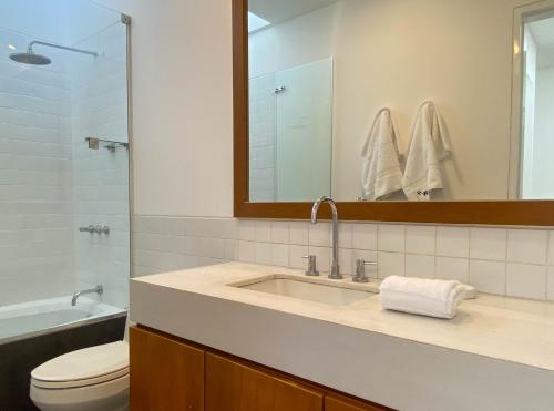 a bathroom with a sink and a toilet and a mirror at Duplex with Balcony in Barranco in Lima
