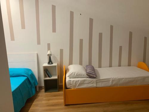 a bedroom with a bed and a striped wall at Casa del sole in Nova Siri Marina