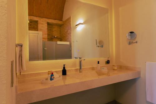 a bathroom with a sink with a large mirror at Víd de Luna San Miguel de Allende in San Miguel de Allende