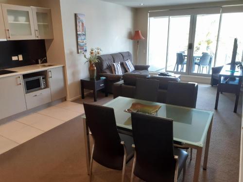 a living room with a table and a couch at Esplanade Apartments in Whitianga