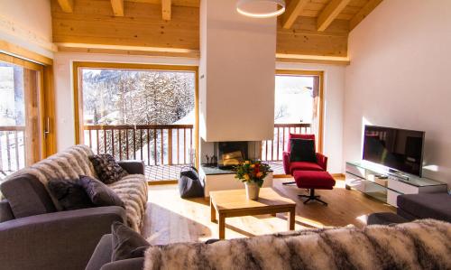 a living room with two couches and a television at Chalet Les Rahâs by Mrs Miggins in Grimentz