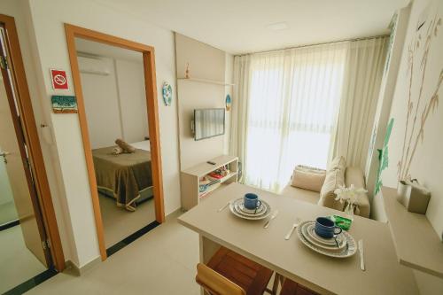 a room with a table and a mirror and a bedroom at Apê aconchegante a 50m do mar - Maracaípe in Porto De Galinhas