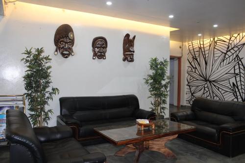 a living room with couches and masks on the wall at Pacific Crown Hotel in Honiara