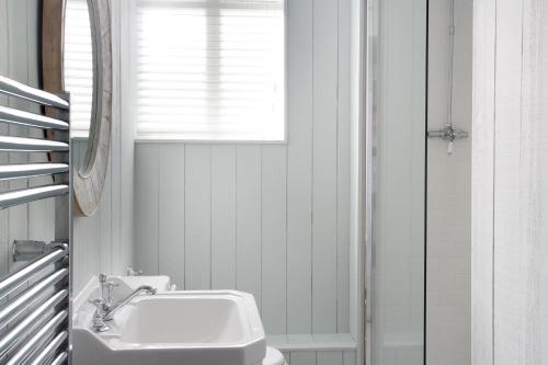 a white bathroom with a sink and a window at Royal Hotel in Deal