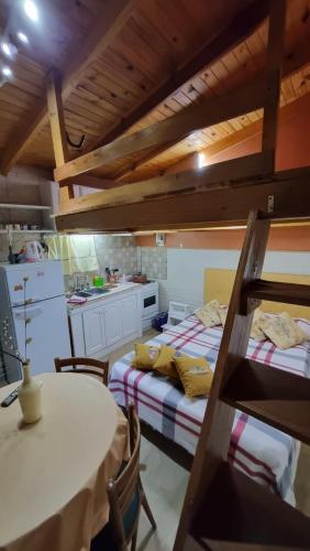 a room with two beds and a table and a kitchen at El buen descanso in Mar de Ajó