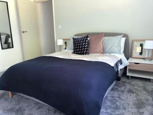 a bedroom with a large bed with pillows on it at Bronte Country - 2 Bed Apartment near Cliffe Castle in Keighley