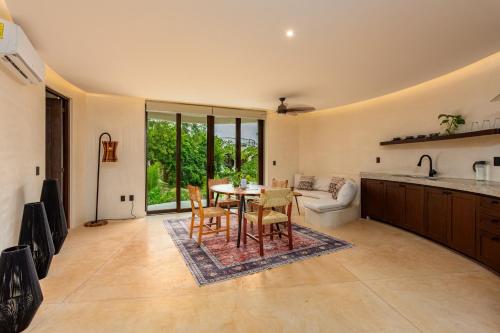 a kitchen and living room with a table and chairs at Kan Tulum Hotel in Tulum