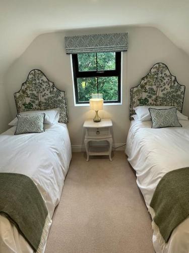two twin beds in a room with a window at Littlemount Farm Cottage in Brookeborough
