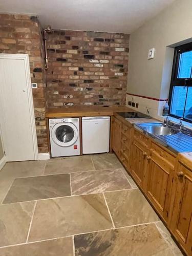 a kitchen with a sink and a washing machine at Littlemount Farm Cottage in Brookeborough