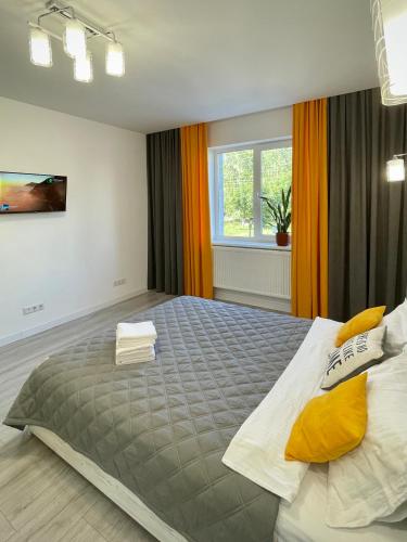 a bedroom with a large bed with yellow pillows at Oberig Royal Apartments НОВОБУДОВА, найкращий район, дуже ЧИСТО in Chernivtsi