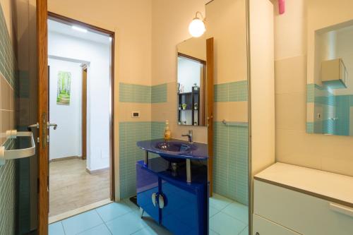 a bathroom with a blue sink and a shower at L'originario Salviano Family Apartment in Livorno