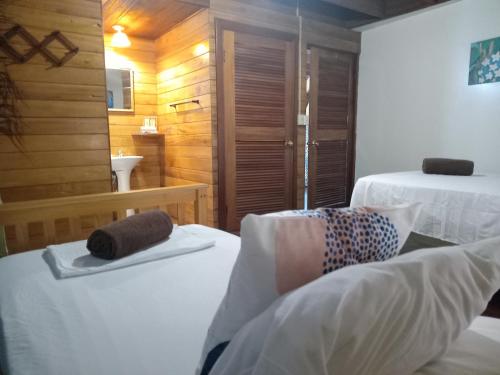 a hotel room with two beds and a bathroom at Villa Bahia Del Sol in Bocas del Toro