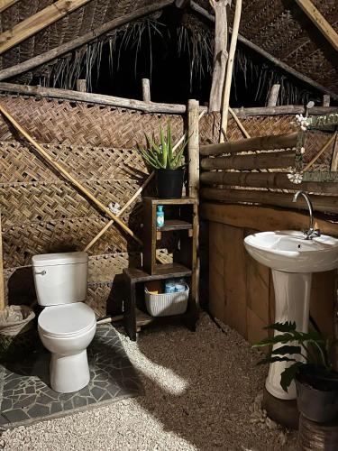 a bathroom with a toilet and a sink at Te Fare Ninamu Maupiti in Te-Fare-Arii