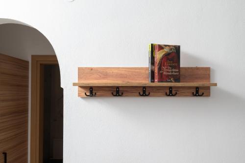 a book sitting on a wooden shelf on a wall at Blue Horizon Apartments in Stalida
