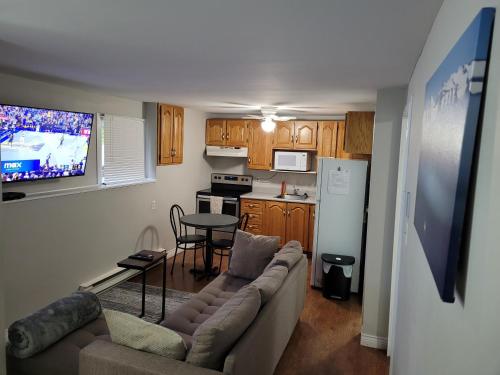 a living room with a couch and a table and a kitchen at Full 1-bedroom apartment in St. John's