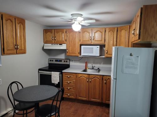 a kitchen with wooden cabinets and a table and a refrigerator at Full 1-bedroom apartment in St. John's