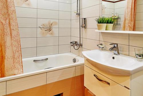 uma casa de banho com um lavatório e uma banheira em Apartament Volga River em Saratov